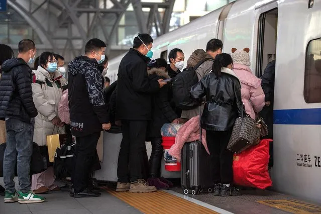 This photo taken on January 7, 2023 shows passengers preparing to board their train at Hankou railway station on the first day of peak travel ahead of the Lunar New Year of the Rabbit in Wuhan, in China's central Hubei province. (Photo by AFP Photo/China Stringer Network)