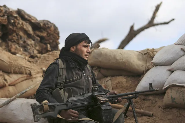 A rebel fighter from the Free Syrian Army's Al Rahman legion takes up position behind sandbags in Jobar, a suburb of Damascus December 22, 2014. (Photo by Bassam Khabieh/Reuters)