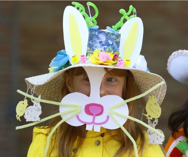 Maggie McCrate, 7, of Wheaton, Ill., smiles during the the Easter Bonnet Contest following the Downtown Wheaton Association's 10th annual Easter egg hunt in Memorial Park in Wheaton, Ill., Saturday, March 26, 2016. (Photo by Daniel White/Daily Herald via AP Photo)