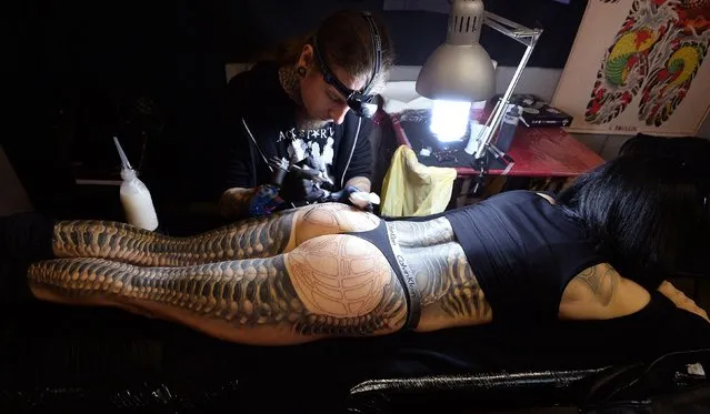 Tattoo artist Kali applies a tattoo to Aneta von Cyborg at the 2017 Tattoo Collective event at the Old Truman Brewery in London, England on February 17, 2017. (Photo by PA Wire)