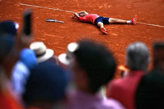 Serbia's Novak Djokovic lays on the court as he celebrates his victory over Norway's Casper Ruud during their men's singles final match on day fifteen of the Roland-Garros Open tennis tournament at the Court Philippe-Chatrier in Paris on June 11, 2023. (Photo by Julien de Rosa/AFP Photo)