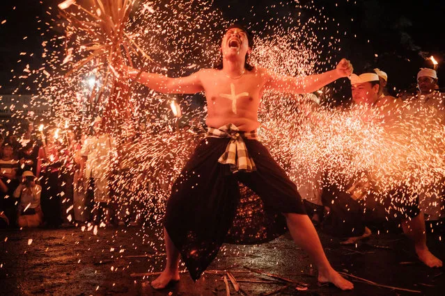 Men fight with burning coconut leaves as a ritual of ablution by fire during “Lukat Geni” in Bali on March 10, 2024, on the eve of Nyepi. Hindus in Indonesia, the world's largest Muslim-populated nation, will celebrate the “Day of Silence”, locally known as Nyepi, on March 11. (Photo by Yasuyoshi Chiba/AFP Photo)