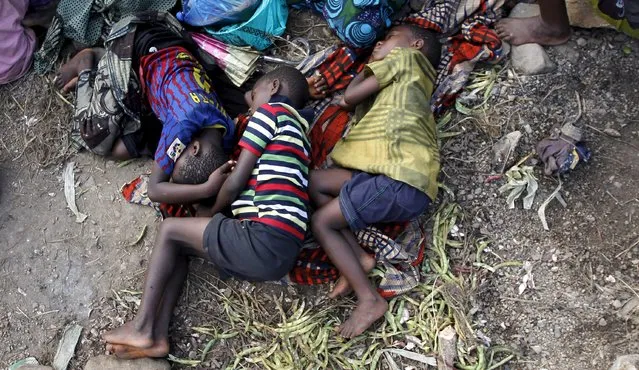 Sick Burundian refugees sleep as they wait for treatment at a makeshift clinic on the shores of Lake Tanganyika in Kagunga village in Kigoma region in western Tanzania, as they wait for MV Liemba to transport them to Kigoma township, May 17, 2015. (Photo by Thomas Mukoya/Reuters)