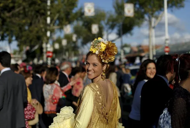 A woman wearing a sevillana dress smiles during the traditional Feria de Abril (April fair) in the Andalusian capital of Seville, southern Spain, April 13, 2016. (Photo by Marcelo del Pozo/Reuters)