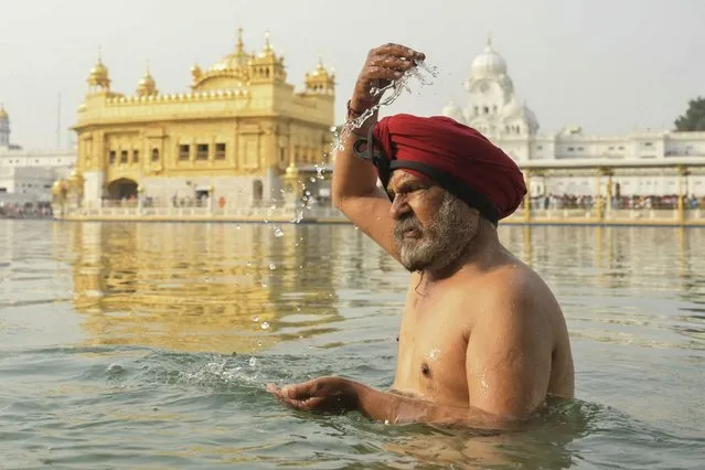 A Sikh devotee bathes in the holy sarovar (water tank) on the occasion of “Baisakhi”, a spring harvest festival, in Amritsar on April 13, 2024. (Photo by Narinder Nanu/AFP Photo)