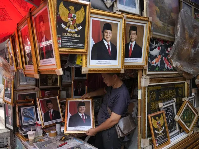 A vendor holds a portrait of Indonesian President-elect and Defense Minister Prabowo Subianto at a market in Jakarta, Indonesia, Wednesday, April 24, 2024. Indonesia's electoral commission formally declared Subianto as the elected president in a ceremony on Wednesday after the country's highest court rejected appeals lodged by two losing presidential candidates who are challenging his landslide victory. (Photo by Achmad Ibrahim/AP Photo)