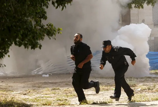 Palestinian policemen loyal to Hamas run as they reenact a scene of an explosion during a drill, in Gaza City April 19, 2016. (Photo by Suhaib Salem/Reuters)