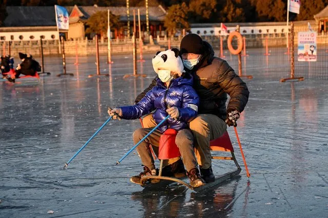 People skate on a frozen lake at the Summer Palace in Beijing on January 12, 2022. (Photo by Jade Gao/AFP Photo)
