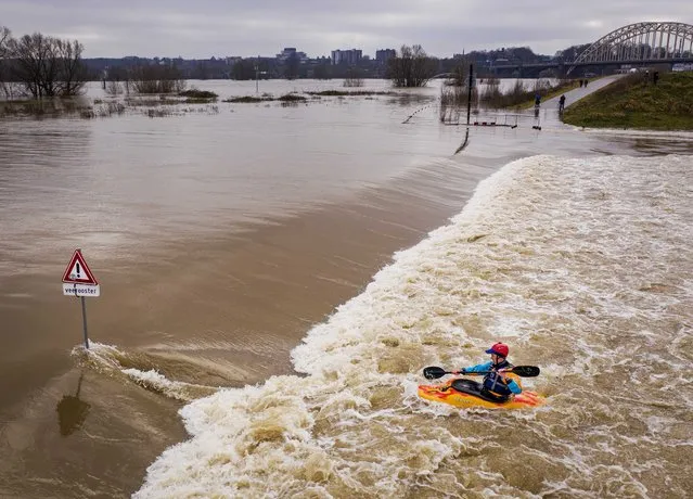 A picture taken with a drones shows a Kayaker makes use of the current that flows over a dike in the flood plains of the Waal river, with the Waal bridge of Nijmegen in the background in Lent, the Netherlands, 04 February 2021. The heavy rainfall and snow melt in southern Germany has caused a significant rise in the water level in various places in the Netherlands. (Photo by Robin Van Lonkhuijsen/EPA/EFE)
