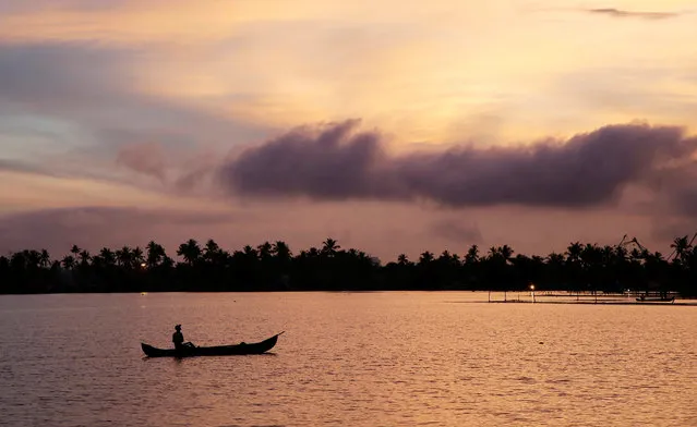 A man rows his boat in the tributary waters of Vembanad Lake against the backdrop of pre-monsoon clouds on the outskirts of Kochi, India, June 7, 2019. (Photo by Sivaram V/Reuters)