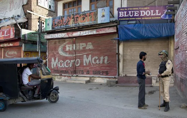 An Indian paramilitary soldier interrogates a Kashmiri man at a temporary checkpoint in Srinagar, Indian controlled Kashmir, Thursday, May 21, 2015. (Photo by Dar Yasin/AP Photo)