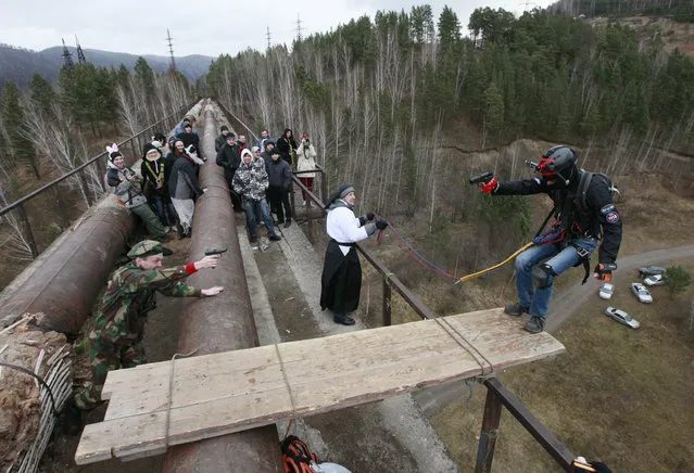 Members of the “Exit Point” amateur rope-jumping group stage a performance as they jump from a 44-metre high (144-ft) waterpipe bridge in the Siberian Taiga area outside Krasnoyarsk, November 3, 2013. (Photo by Ilya Naymushin/Reuters)