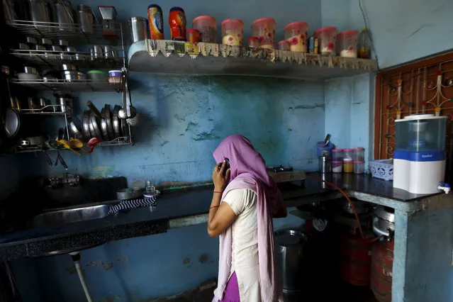 A woman in Uttar Pradesh speaks on a mobile phone inside the kitchen of her house at Sankrod village in Baghpat district, India, September 1, 2015. (Photo by Adnan Abidi/Reuters)
