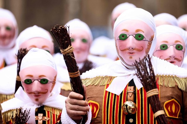 Revellers dressed as a “Gilles”, the oldest and principal participants in the Carnival of Binche in Belgium, take part in the parade in Binche on February 21, 2023. (Photo by Kenzo Tribouillard/AFP Photo)
