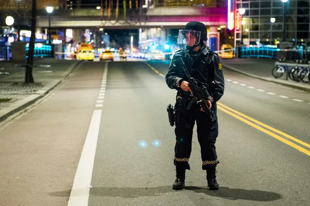 An officer stands guard as police cordon off a large area around a subway station on a busy commercial street Saturday night, April 8, 2017, after finding what they described as a “bomb-like” device, in Oslo, Norway. The official police Twitter account said one man has been arrested and Police Chief Vidar Pedersen said police were working to disarm it. (Photo by Fredrik Varfjell/NTB scanpix via AP Photo)
