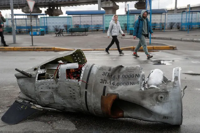People walk past the remains of a missile at a bus terminal, as Russia's invasion of Ukraine continues, in Kyiv, Ukraine on March 4, 2022. (Photo by Valentyn Ogirenko/Reuters)