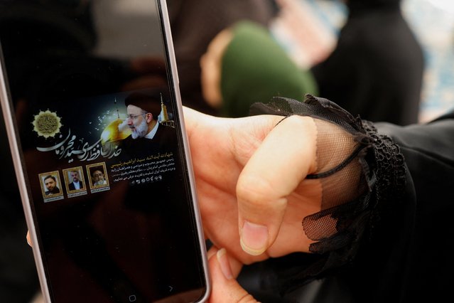 An Iranian Shi'ite pilgrim shows the news on her phone after the death of Iranian President Ebrahim Raisi in a helicopter crash, at the Imam Ali shrine in the holy city of Najaf, Iraq on May 20, 2024. (Photo by Alaa Al-Marjani/Reuters)