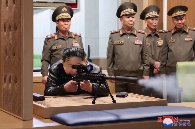 This recent undated picture released by North Korea's official Korean Central News Agency (KCNA) via KNS on May 13, 2024 shows North Korea's leader Kim Jong Un (bottom L) testing a sniper rifle during a visit to a national defence industrial enterprise at an undisclosed location in North Korea. (Photo by KCNA via KNS/AFP Photo)