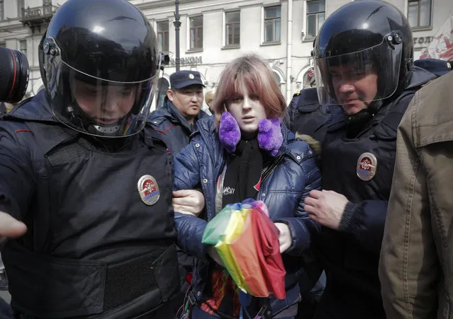A gay rights activist holding a rainbow umbrella is detained by police during a rally marking May Day in downtown St. Petersburg, Russia, Monday, May 1, 2017. (Photo by Dmitri Lovetsky/AP Photo)