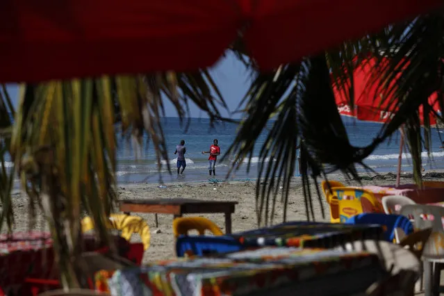 Fishermen pull in a net, seen through an empty beach restaurant near Jacmel, Haiti, Sunday, October 6, 2019. (Photo by Rebecca Blackwell/AP Photo)
