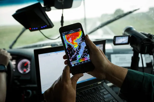 OLUSTEE, OK - MAY 10: Support scientist Tim Marshall, a 40 year veteran of storm chasing, looks at radar on his smartphone as the group tracks a supercell thunderstorm, May 10, 2017 in Olustee, Oklahoma. Wednesday was the group's third day in the field for the 2017 tornado season for their research project titled 'TWIRL.' With funding from the National Science Foundation and other government grants, scientists and meteorologists from the Center for Severe Weather Research try to get close to supercell storms and tornadoes trying to better understand tornado structure and strength, how low-level winds affect and damage buildings, and to learn more about tornado formation and prediction.   Drew Angerer/Getty Images/AFP