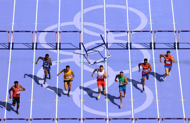 Athletes jumping hurdles in heat 1 of men's 110m hurdles round 1 on August 4, 2024. (Photo by Fabrizio Bensch/Reuters)