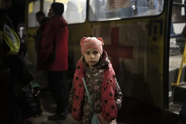 An internally displaced girl waits for family members outside the bus as they arrive in Zaporizhzhia, Ukraine, Friday, April 1, 2022. (Photo by Felipe Dana/AP Photo)