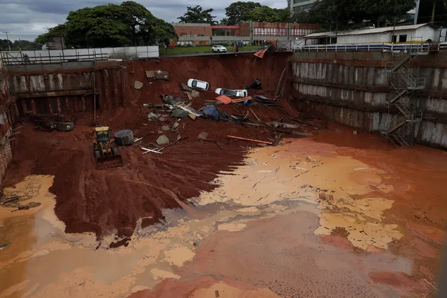 Vehicles lay at the bottom of a construction site after a road collapsed due to heavy rains in the center of Brasilia, Brazil, Tuesday, December 10, 2019. There were no victims reported. (Photo by Eraldo Peres/AP Photo)