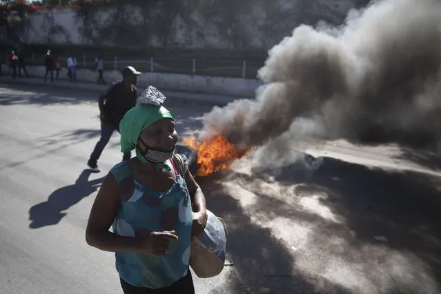 A protester balances a rock on her head as a symbol of penance during a protest by factory workers demanding salary increases in Port-au-Prince, Haiti, Wednesday, February 23, 2022. (Photo by Joseph Odelyn/AP Photo)