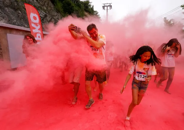 Participants run through coloured powder during the YARKOcross colour run race in Almaty, Kazakhstan, June 5, 2016. (Photo by Shamil Zhumatov/Reuters)