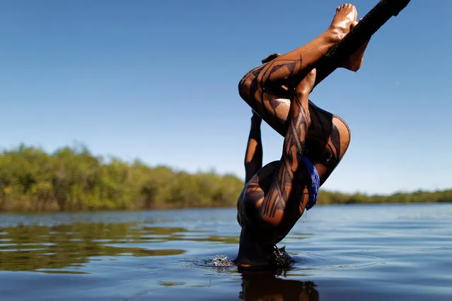 A Yawalapiti boy dips his head into the Xingu River in the Xingu National Park, Mato Grosso State, Brazil, May 9, 2012. (Photo by Ueslei Marcelino/Reuters)