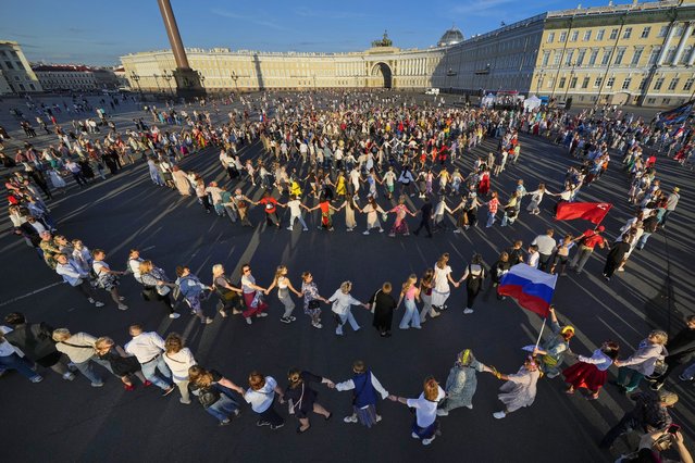 People dance during a round dance flashmob at the Palace Square in St. Petersburg, Russia, Thursday, August 15, 2024. (Photo by Dmitri Lovetsky/AP Photo)