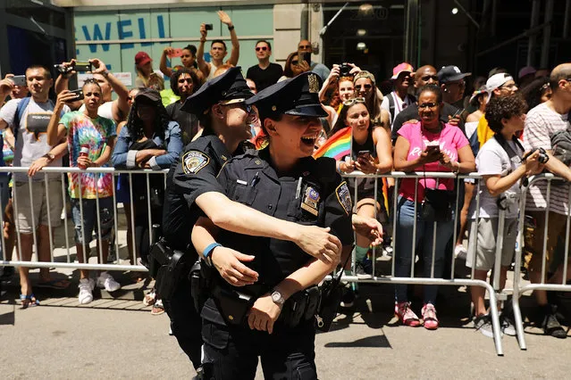 Two female police officers embrace as people march down 5th Ave. in the annual New York Gay Pride Parade, one of the oldest and largest in the world on June 25, 2017 in New York City. Thouands cheered as members of LGBT community danced and marched under a bright summer sun. Many participants carried political themed signs as President Trump's adminstration has angered some in the LGBT community. (Photo by Spencer Platt/Getty Images)
