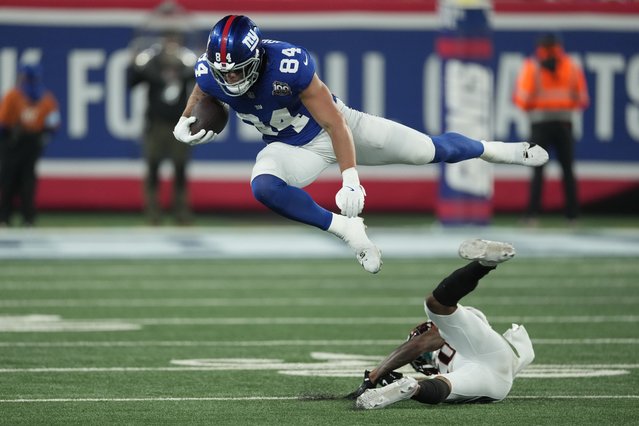 New York Giants tight end Theo Johnson (84) leaps over a Cincinnati Bengals defender during the second half of an NFL football game, Sunday, October 13, 2024, in East Rutherford, N.J. (Photo by Seth Wenig/AP Photo)