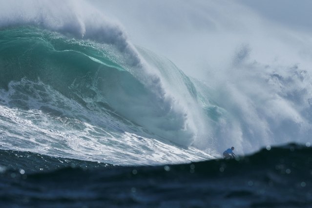 A surfer rides a wave at Dungeons offshore reef in the Atlantic ocean as seasonal cold fronts drive big swells into the Cape Peninsula in Cape Town, South Africa on August 18, 2024. (Photo by Nic Bothma/Reuters)