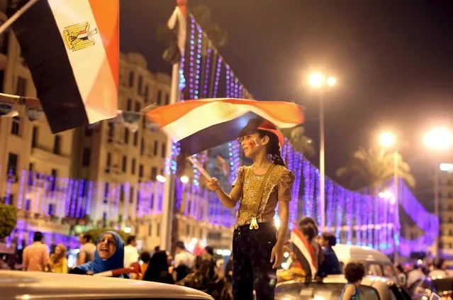 A girl waves an Egyptian flag as people celebrate in Tahrir square in Cairo, Egypt, August 6, 2015. Egypt will open an expansion to the Suez Canal to great fanfare on Thursday, the centrepiece of President Abdel Fattah al-Sisi's plans to revitalise the country's economy after years of damaging political turmoil. (Photo by Asmaa Waguih/Reuters)