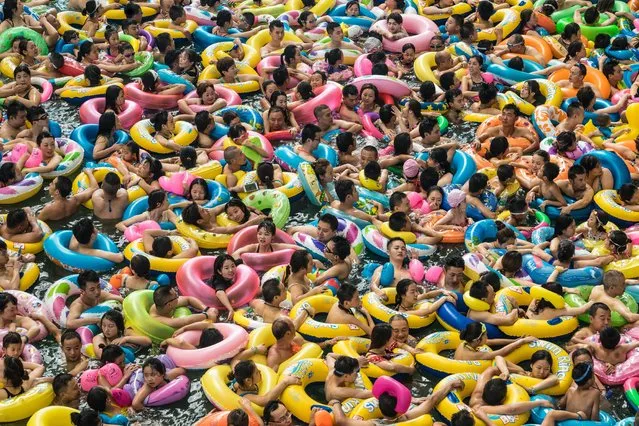 Chinese tourists with swim rings enjoy swimming in the lake called “Dead sea of China” in a resort of Suining city, southwestern China's Sichuan province, 22 July 2017. More than 8,000 tourists gathered enjoy the water during hot weather. (Photo by Lola Levan/EPA/EFE)