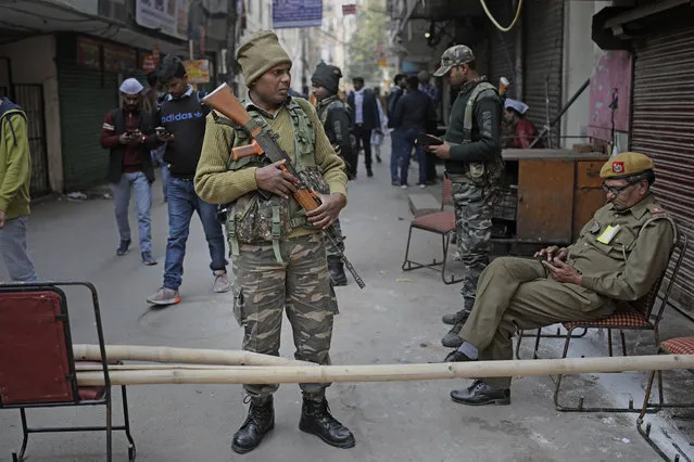 A paramilitary soldier stands guard outside a polling station closest to the Shaheen Bagh protest where Muslim women have been protesting for weeks against a new citizenship law, in New Delhi, India, Saturday, February 8, 2020. Voting began for a crucial state election in India's capital on Saturday with Prime Minister Narendra Modi's Hindu nationalist party trying to regain power after a 22-year gap and major victories in a national vote. The BJP campaign has reopened old wounds in the Hindu-Muslim divide and treats the election as a referendum on nearly two months of protests across India against a new citizenship law that excludes Muslims. (Photo by Altaf Qadri/AP Photo)