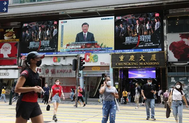 People walk in front of a screen showing Chinese President Xi Jinping speaking during a swearing-in ceremony for Hong Kong's new chief executive John Lee, in Hong Kong, China, 01 July 2022. Chinese President Xi Jinping is visiting the city to mark the 25th Anniversary of the establishment of the Hong Kong Special Administrative Region (HKSAR) of the People’s Republic of China on 01 July 2022. (Photo by Jerome Favre/EPA/EFE)