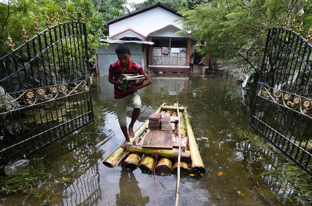 A boy uses a banana raft to transport his books in Jakhalabandha area in Nagaon district, in the northeastern state of Assam, India August 21, 2017. (Photo by Anuwar Hazarika/Reuters)