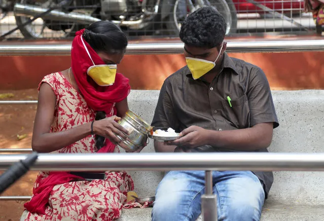 An Indian couple wearing masks prepare to eat their lunch at government run Gandhi Hospital in Hyderabad, India, Friday, March 6, 2020. For weeks India watched as COVID-19 spread in neighboring China and other countries as its own caseload remained static. But with the virus now spreading communally in the country of 1.4 billion and 31 confirmed cases, authorities are scrambling to ready a beleaguered and vastly unequal medical system for a potential surge of patients. (Photo by Mahesh Kumar A./AP Photo)