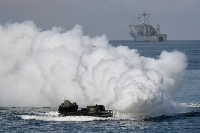 Taiwan's AAV7 amphibious assault vehicle maneuvers across the sea in front of a Newport-class tank landing ship during Amphibious landing drill as part of the Han Kuang military exercise in Pingtung, Taiwan, 28 July 2022. The drill is part of the Taiwan's annual Han Kuang military exercise that simulates response to enemies attack on major targets in Taiwan. (Photo by Ritchie B. Tongo/EPA/EFE)