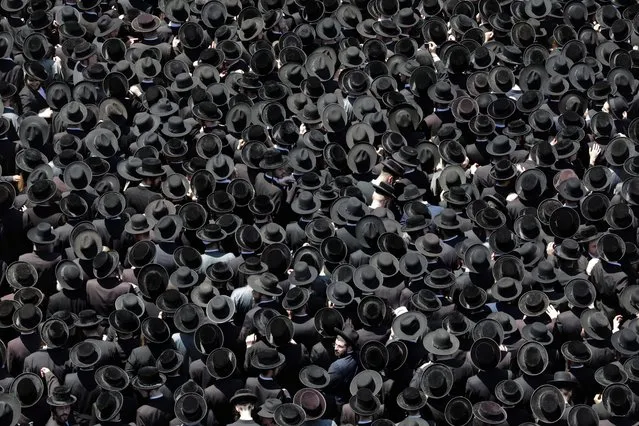Ultra Orthodox Jews gather around the body of Rabbi Yitzchok Tuvia Weiss during his funeral in Mea Shearim neighborhood in Jerusalem, Israel, 31 July 2022. Thousands attended the funeral of Yitzchok Tuvia Weiss, Chief Rabbi of the Eida Haredit, who died at the age of 95 on 30 July 2022. (Photo by Abir Sultan/EPA/EFE)
