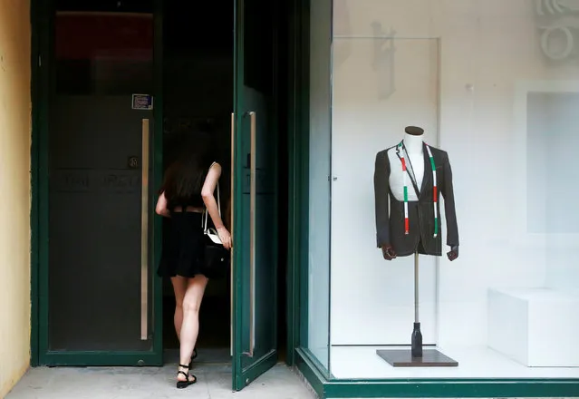 A woman enters a tailor's studio in Beijing, China, July 15, 2016. (Photo by Thomas Peter/Reuters)