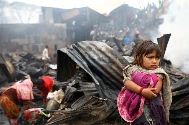 A child looks on, whose shelter has been burned after a fire broke out in a slum in Dhaka, Bangladesh, December 27, 2019. (Photo by Mohammad Ponir Hossain/Reuters)