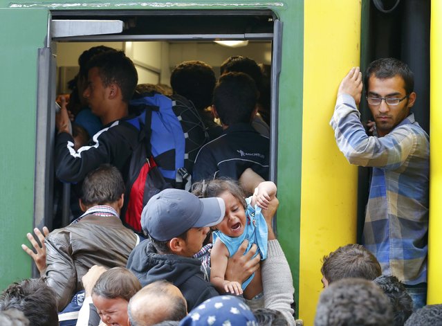 Migrants storm into a train at the Keleti train station in Budapest, Hungary, September 3, 2015 as Hungarian police withdrew from the gates after two days of blocking their entry. (Photo by Laszlo Balogh/Reuters)