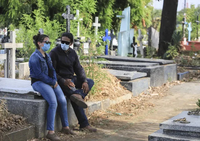 A couple wear masks as they attend a funeral at the Central cemetery of Managua, Nicaragua, Monday, May 11, 2020. President Daniel Ortega's government has stood out for its refusal to impose measures to halt the new coronavirus for more than two months since the disease was first diagnosed in Nicaragua. Now, doctors and family members of apparent victims say, the government has gone from denying the disease's presence in the country to actively trying to conceal its spread. (Photo by Alfredo Zuniga/AP Photo)