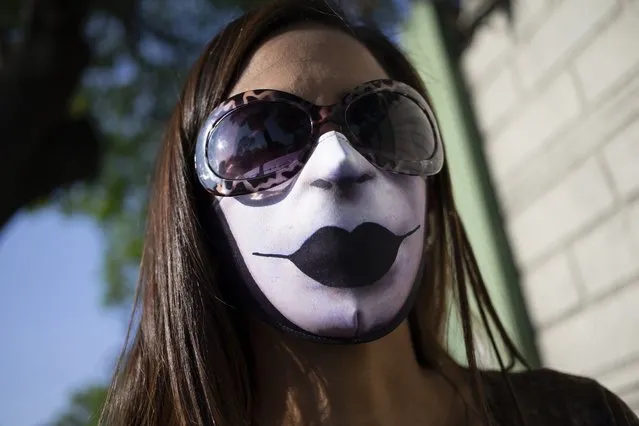 A woman wears a mask with printed lips, amid the spread of the new coronavirus in Caracas, Venezuela, Thursday, April 30, 2020. (Photo by Ariana Cubillos/AP Photo)