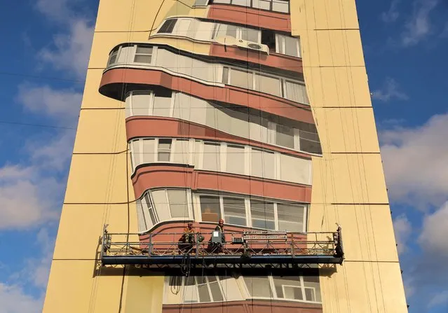 Painters work on a mural on a multi-storey apartment block during the international festival Urban Morphogenesis held in the town of Balashikha outside Moscow, Russia on September 20, 2022. (Photo by Evgenia Novozhenina/Reuters)