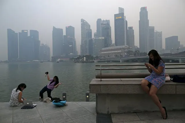 People take photos with the skyline of the central business district shrouded in haze in Singapore September 10, 2015. The 3-hour PSI reading in Singapore was 174 at 17:00 SGT (11:00 GMT) on Thursday. (Photo by Edgar Su/Reuters)
